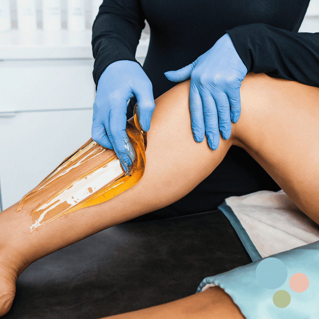 Sugaring hair removal on leg with blue-gloved hands in a spa setting.